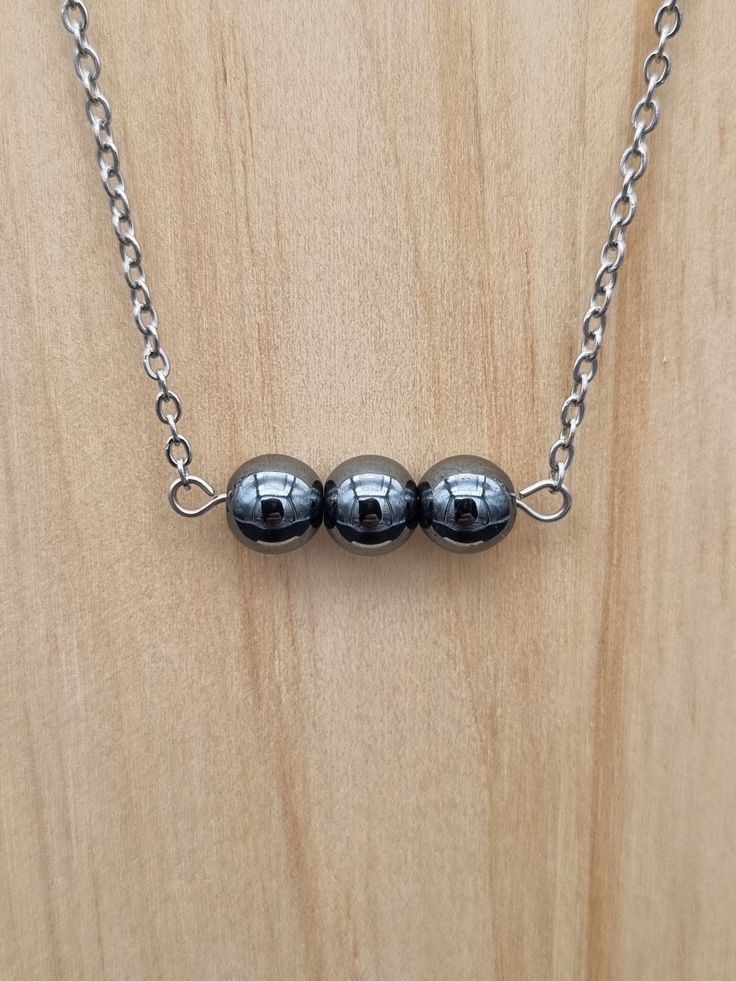 Collier en acier inoxydable avec trois perles d’hématite, création artisanale unique fait main en Gironde.