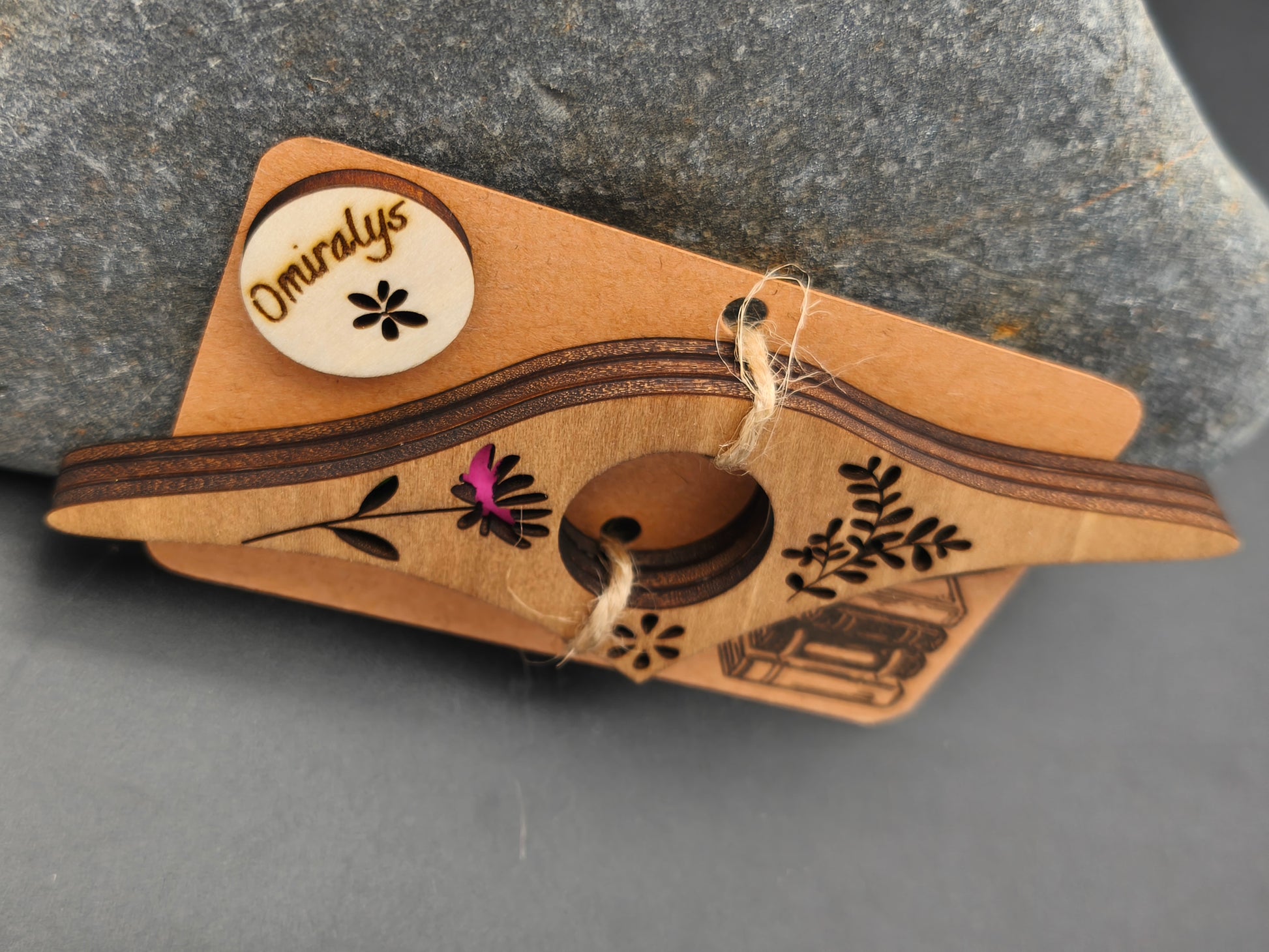 Détail des 3 couches de bois de tilleul (9 mm d'épaisseur) et finitions colorées d'une bague de lecture artisanale fleurie.
