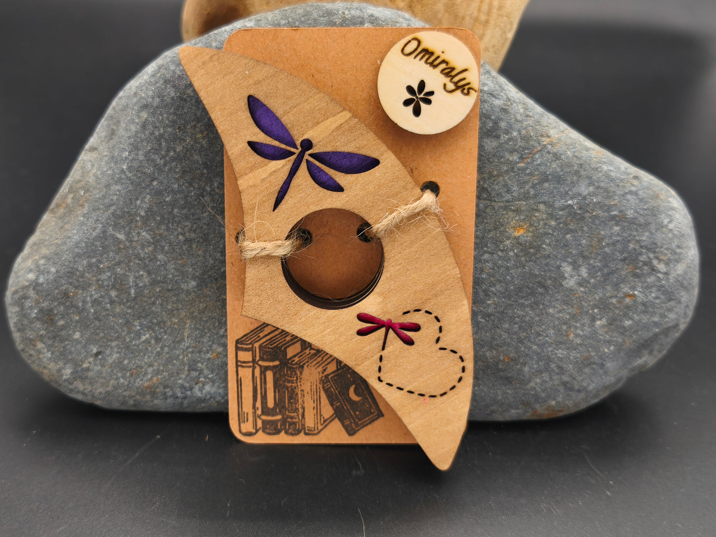 Bague de lecture artisanale Omiralys en bois de tilleul avec libellule violette, sillage de cœur en pointillés et petite libellule rouge en relief 3D.