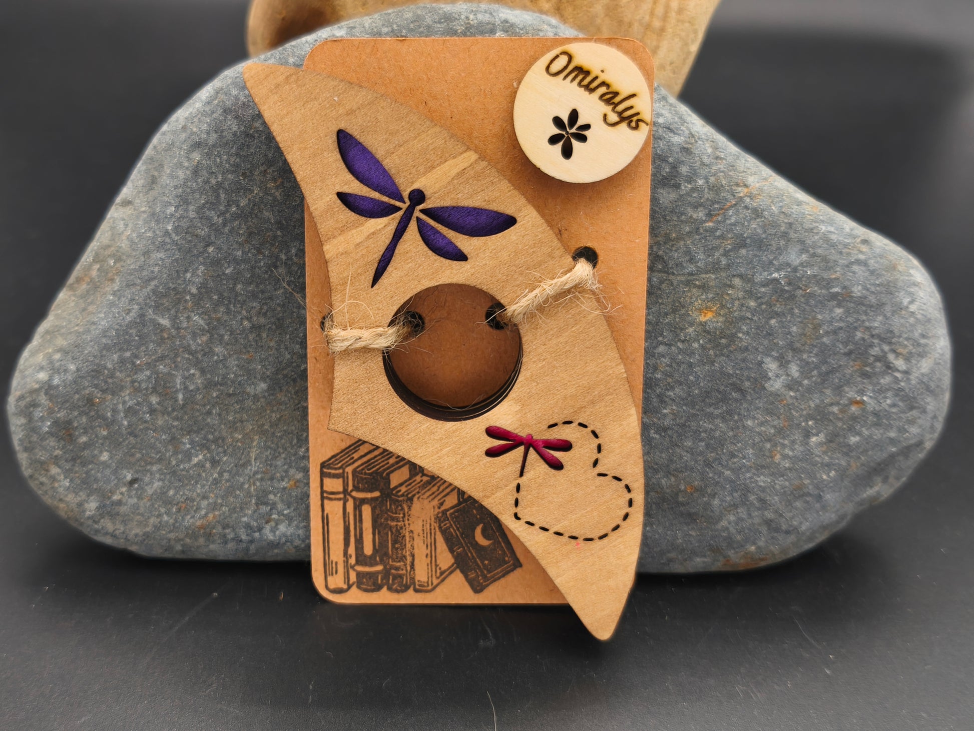 Bague de lecture artisanale Omiralys en bois de tilleul avec libellule violette, sillage de cœur en pointillés et petite libellule rouge en relief 3D.