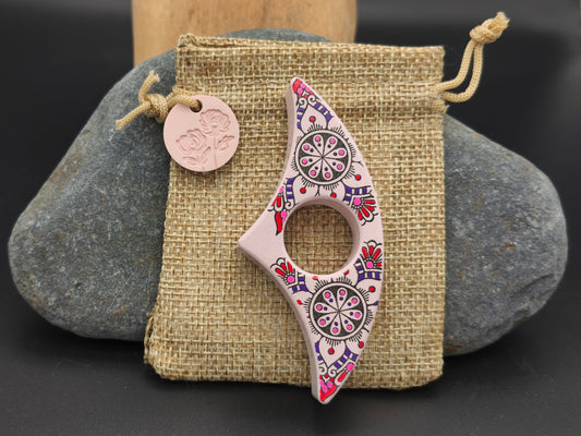 Bague de lecture artisanale Gamme Distinguée – décor mandala floral rose et violet sur pochon en toile de jute