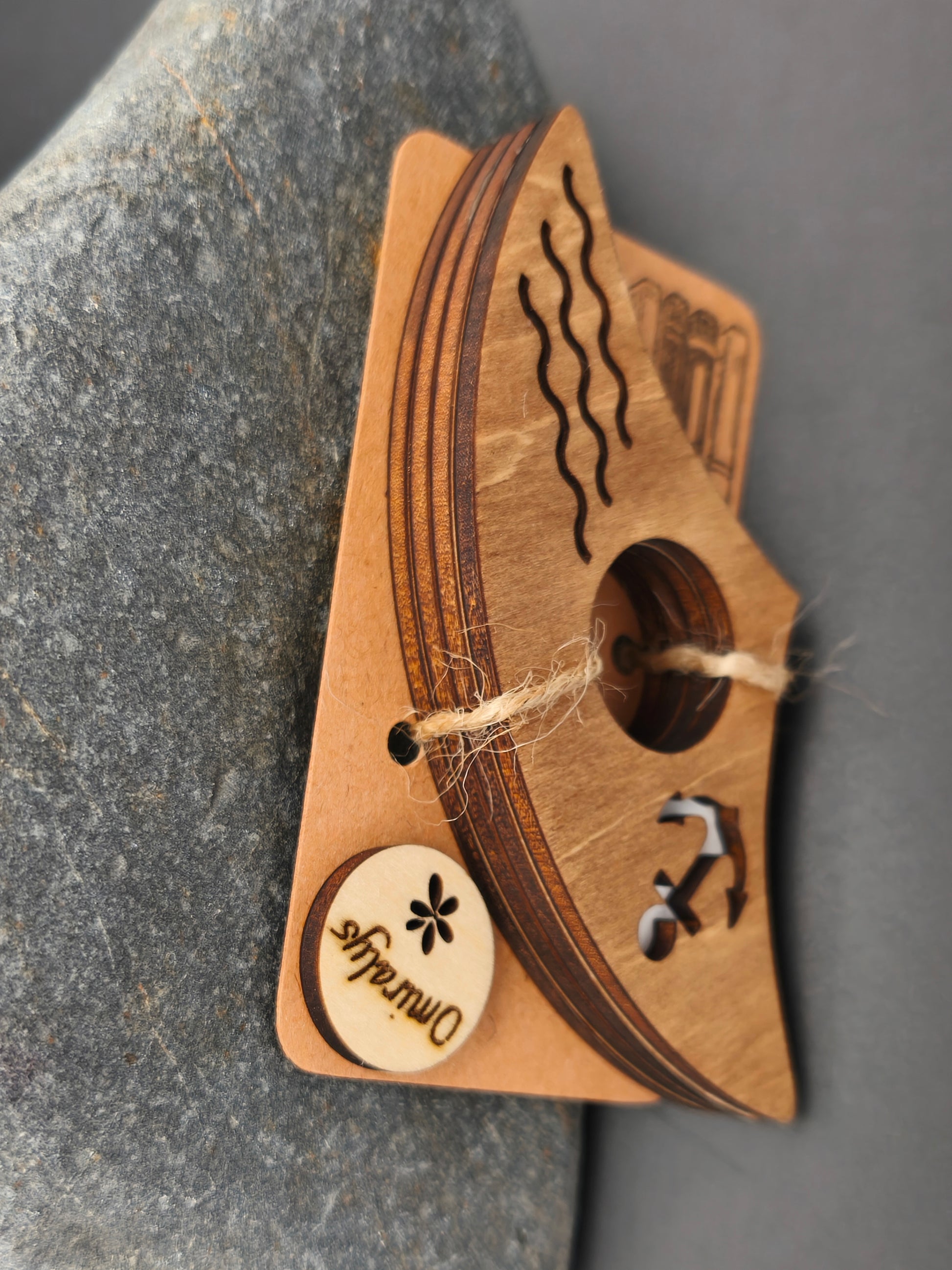 Zoom sur les 4 couches de bois de tilleul (12 mm) et la patine au brou de noix d'une bague de lecture artisanale marine.
