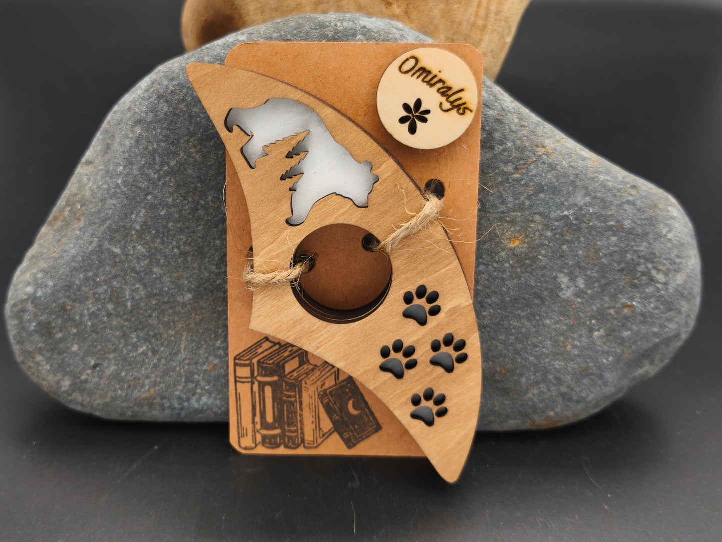 Bague de lecture artisanale Omiralys en bois de tilleul avec silhouette d'ours polaire et empreintes de pas noires en relief 3D sur support kraft.