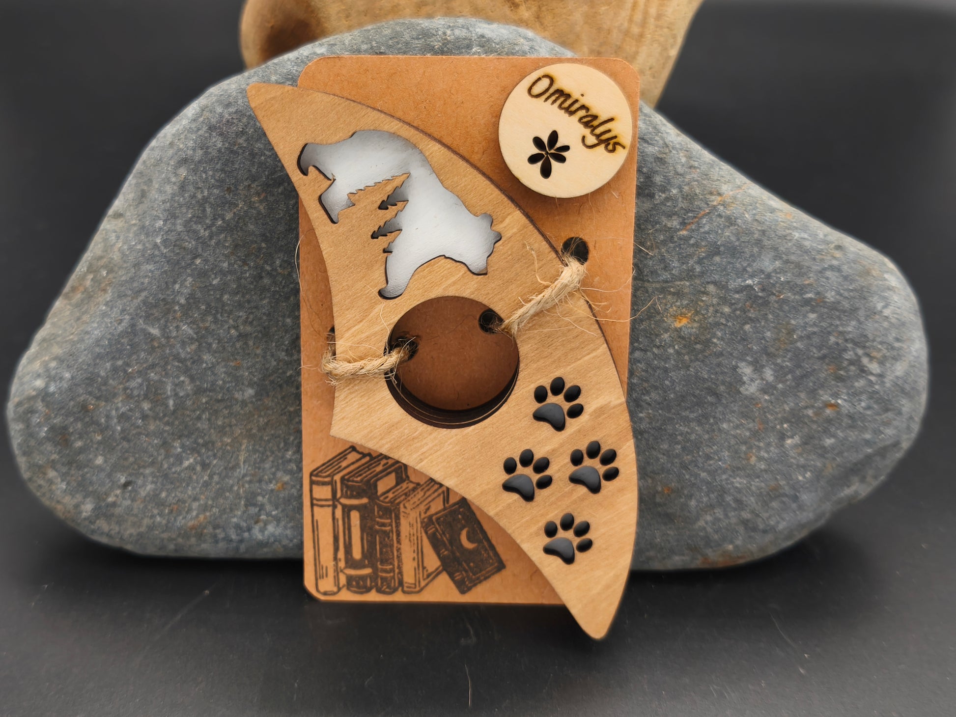 Bague de lecture artisanale Omiralys en bois de tilleul avec silhouette d'ours polaire et empreintes de pas noires en relief 3D sur support kraft.