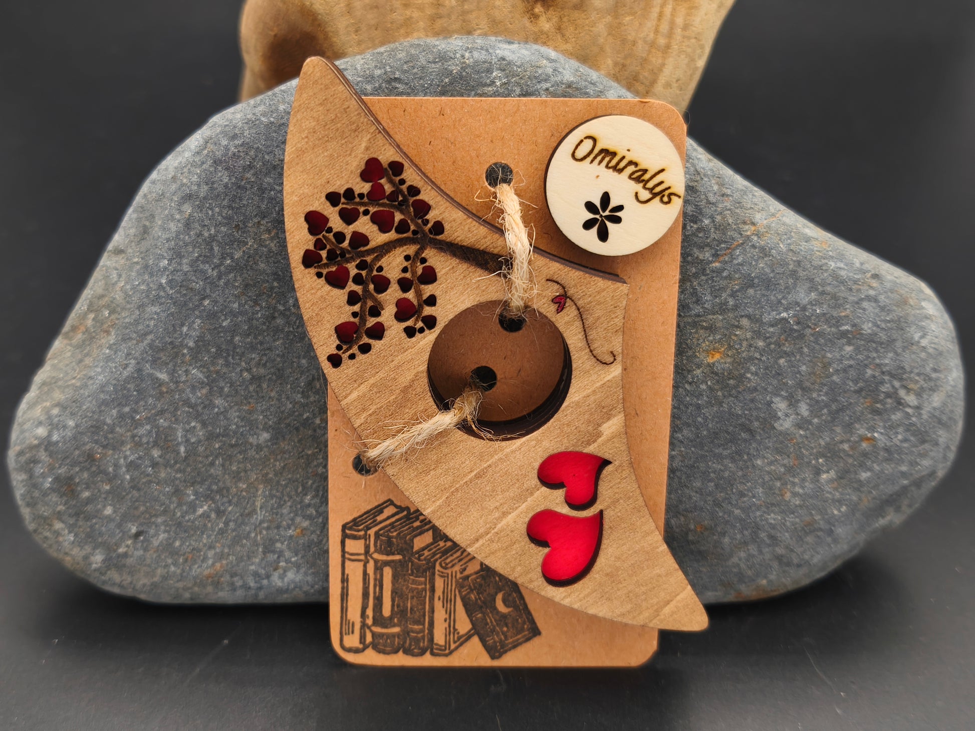 Bague de lecture artisanale Omiralys en bois de tilleul avec silhouette d'ours polaire et empreintes de pas noires en relief 3D sur support kraft.