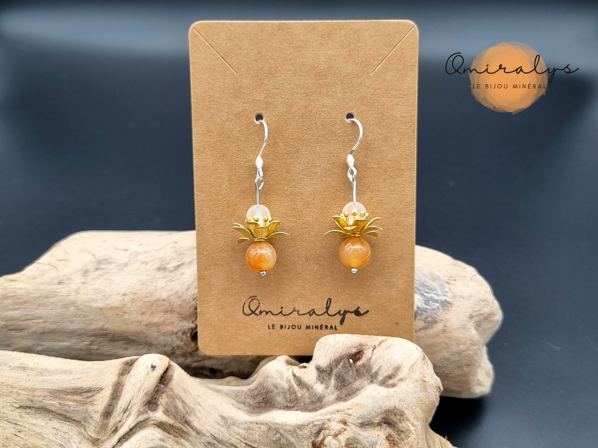 Boucles d'oreilles cornaline et cristal de roche exposées sur une carte présentoir en carton.