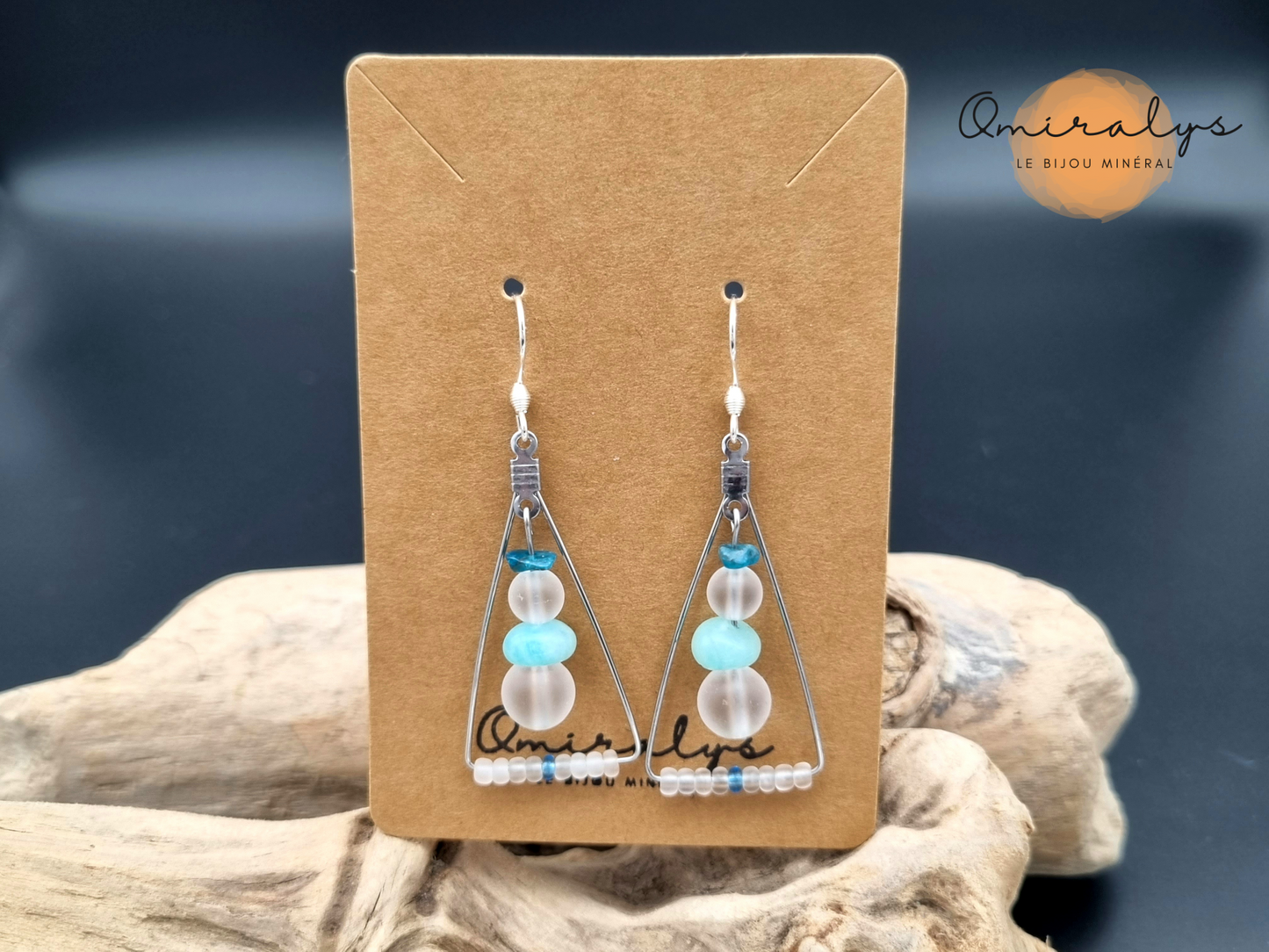 Boucles d'oreilles cristal de roche, amazonite et apatite exposées sur une carte présentoir en carton. 