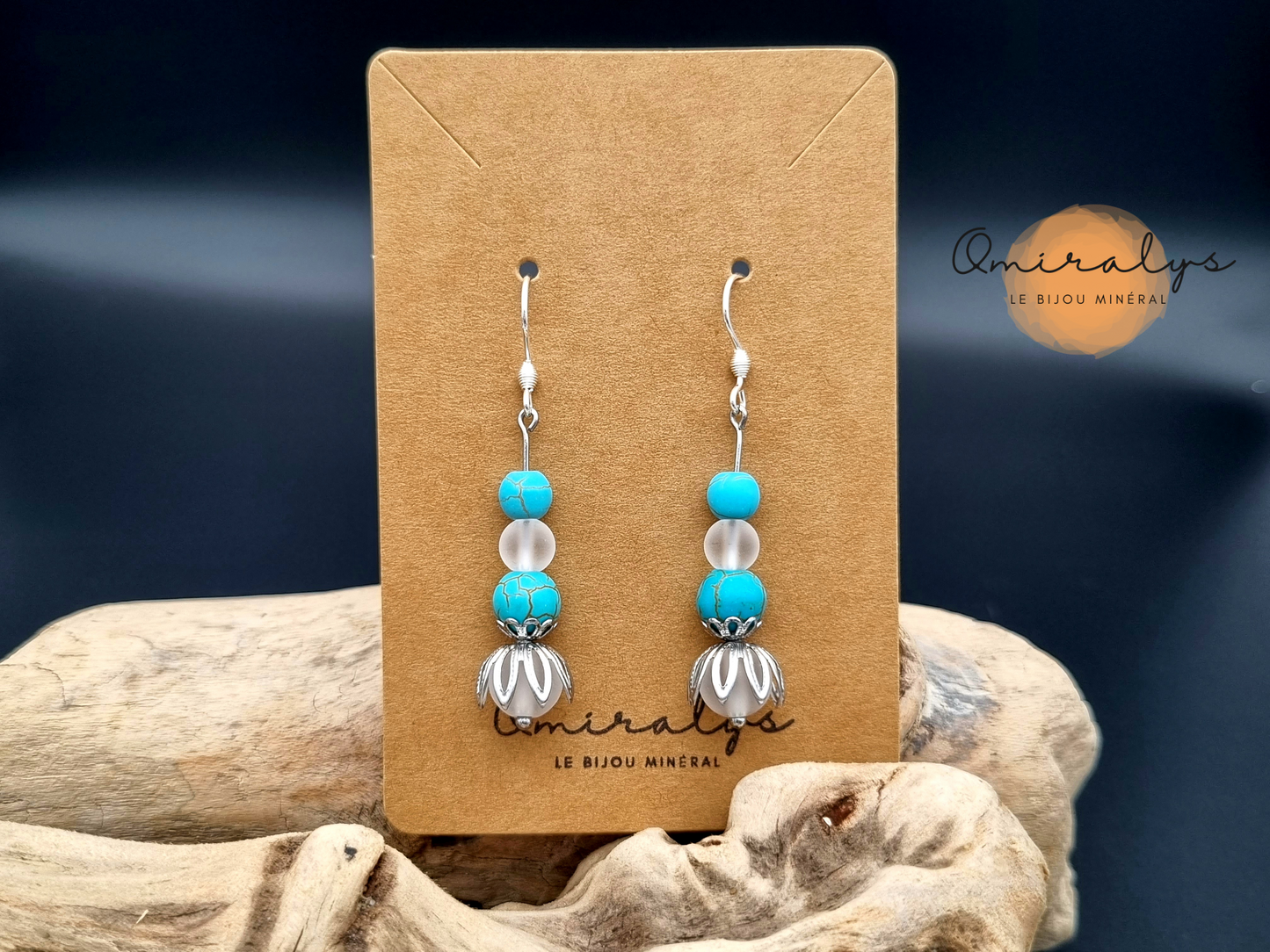 Boucles d'oreilles cristal de roche et howlite turquoise  exposées sur une carte présentoir en carton.