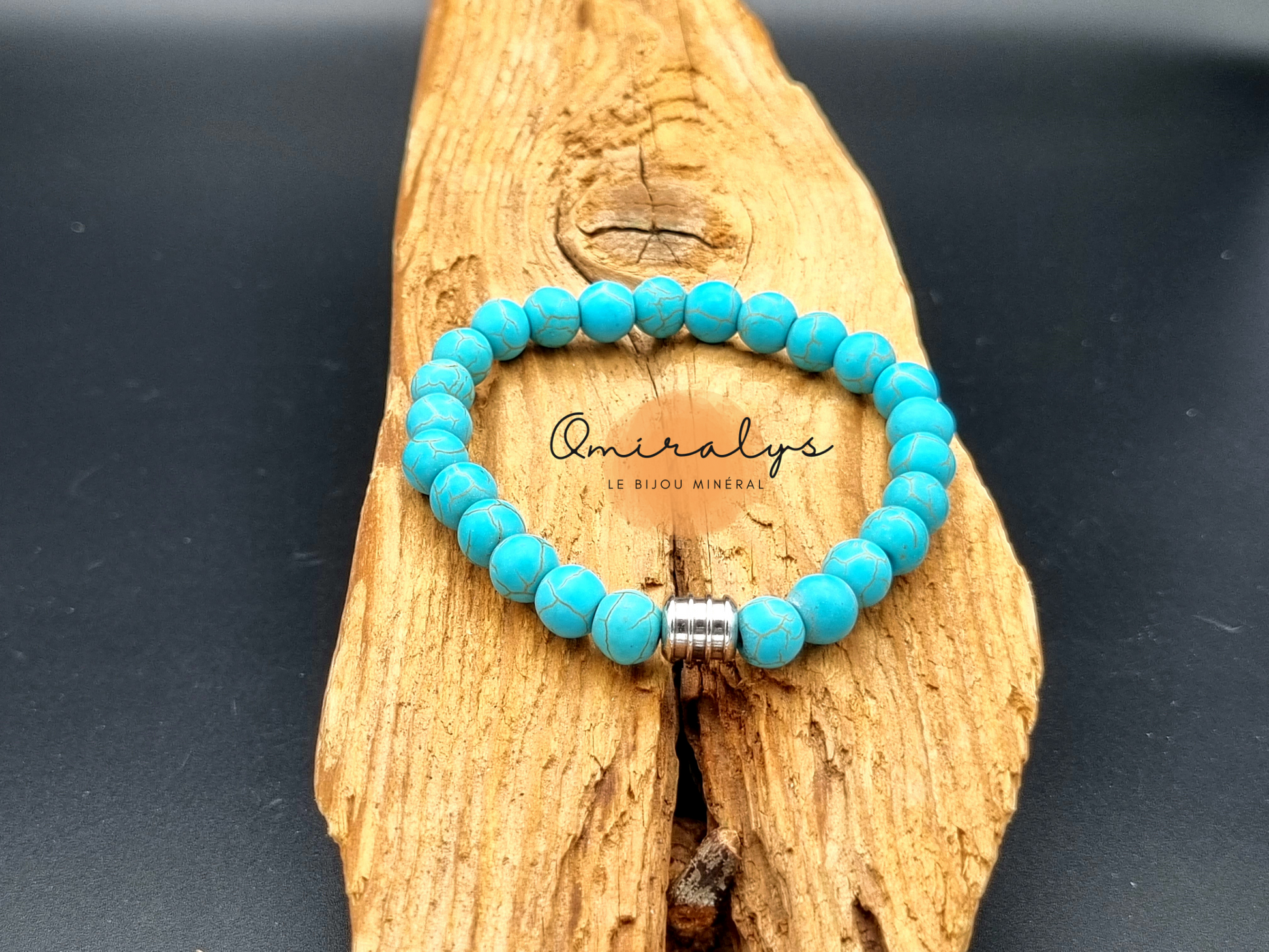 Bracelet howlite turquoise qui repose sur un morceau de bois.