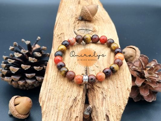 Bracelet jaspe impérial orange, jaspe acajou et œil du tigre qui repose sur un morceau de bois. 