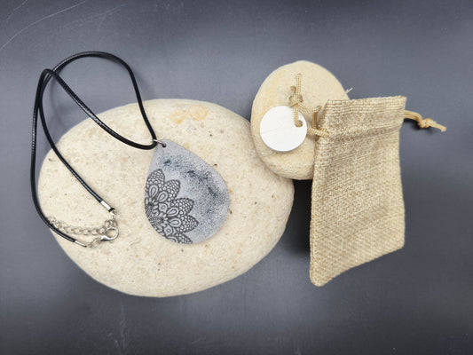 Collier unique Omiralys modèle Floretoile avec pendentif goutte gris, motif floral noir et pluie de paillettes fines.