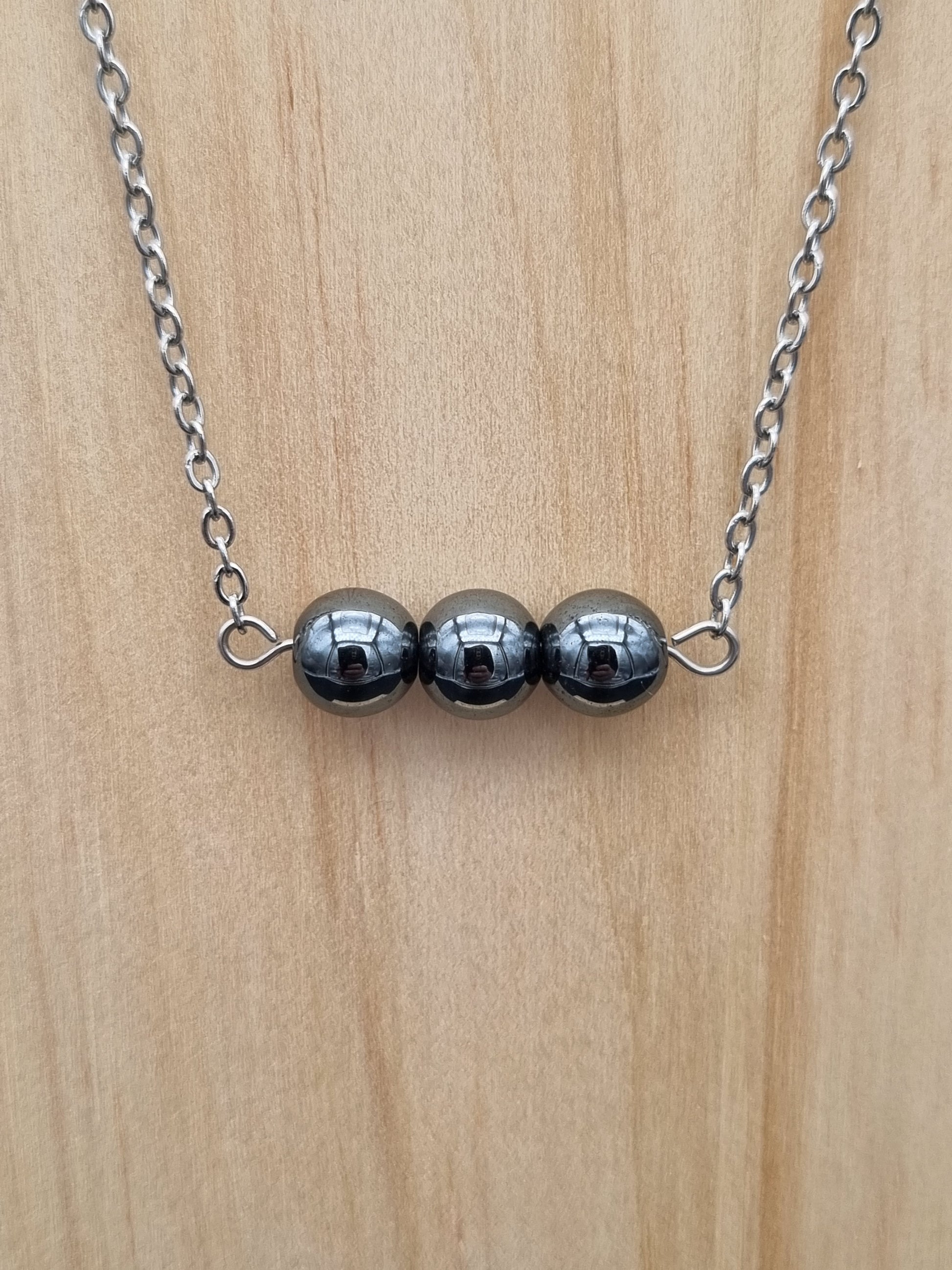 Collier en acier inoxydable avec trois perles d’hématite, création artisanale unique fait main en Gironde.