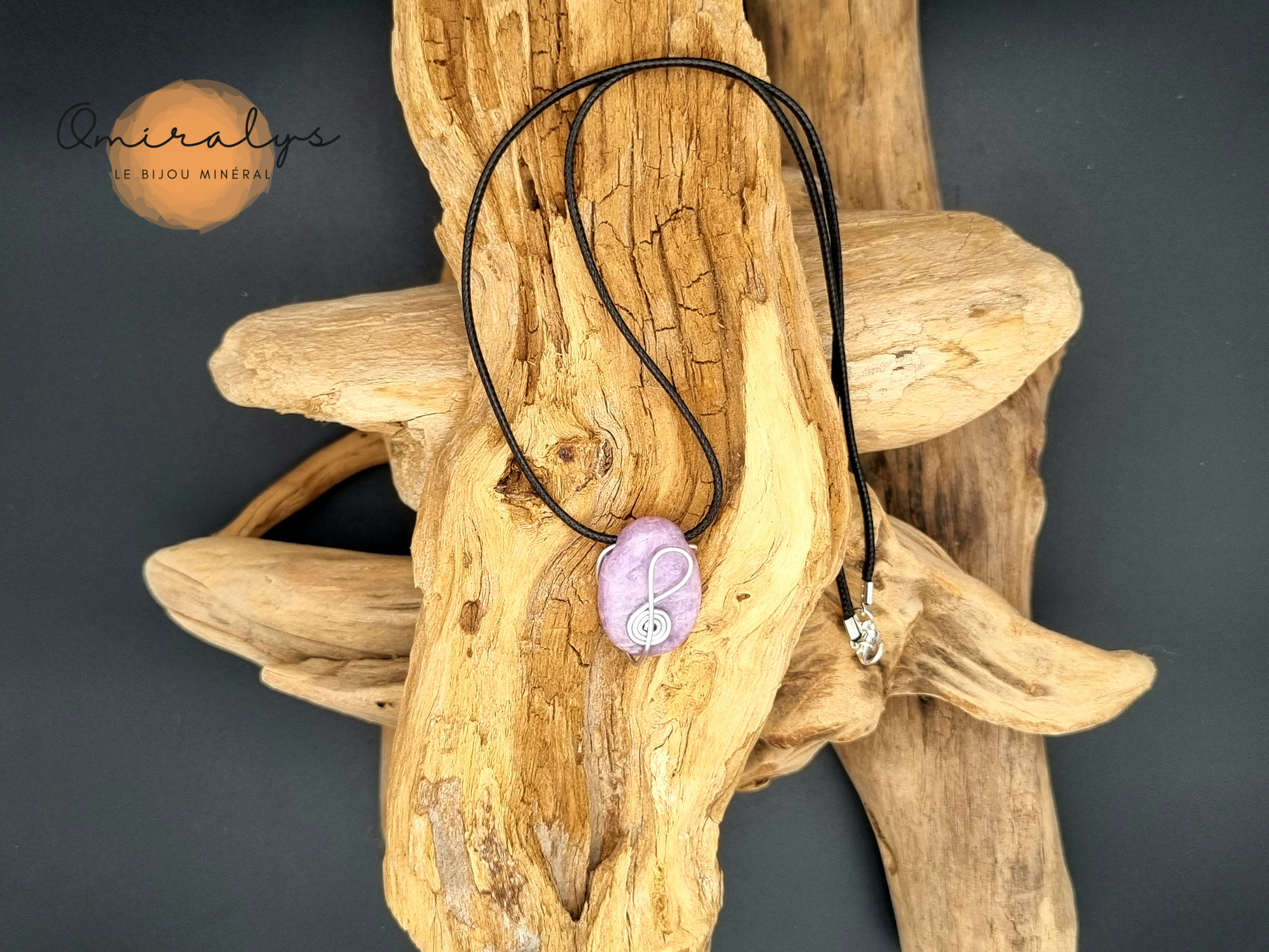 Collier lépidolite présenté sur un morceau de bois flotté.