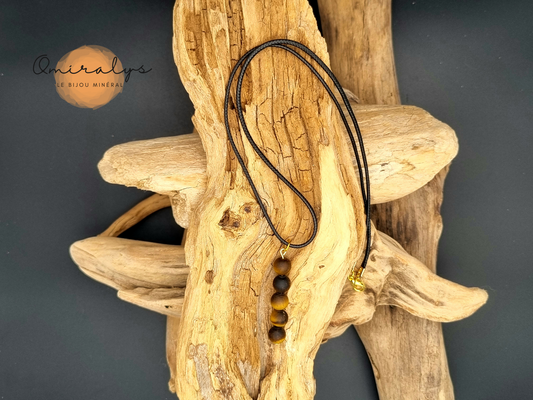 Collier Œil du tigre mat présenté sur un morceau de bois flotté