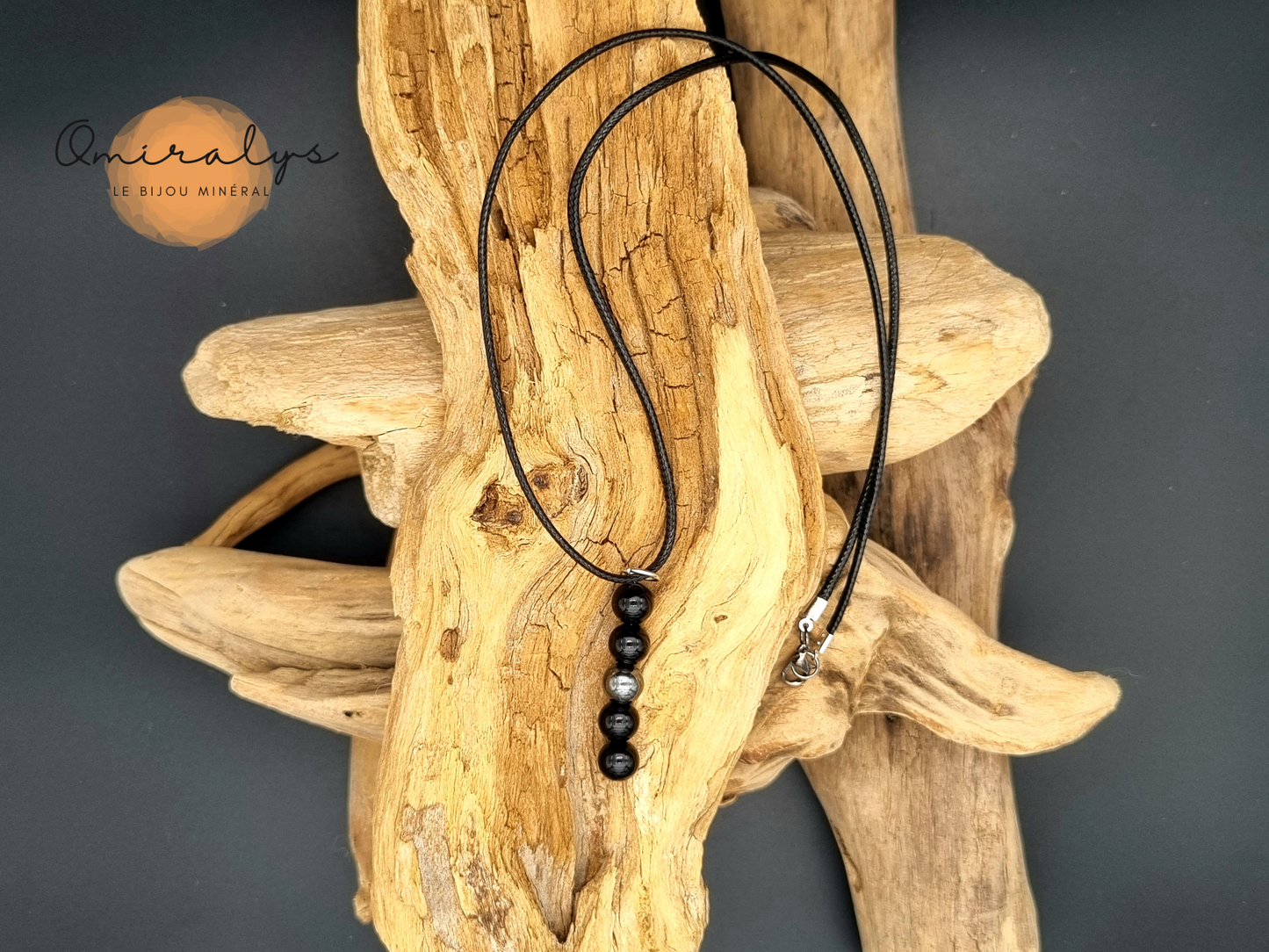 Collier onyx et hématite en perles 8mm présenté sur un morceau de bois flotté