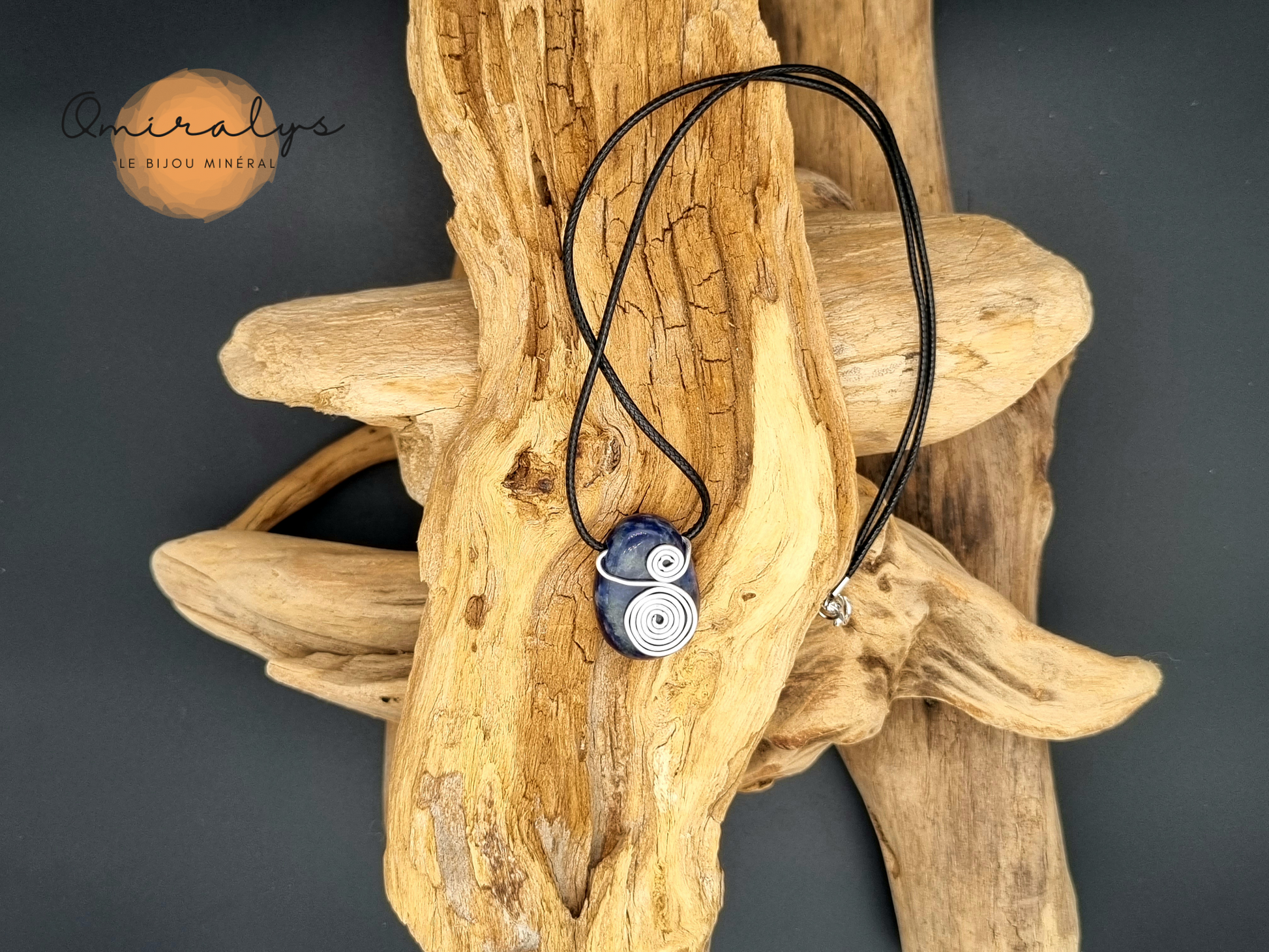 Collier en sodalite présenté sur un morceau de bois flotté