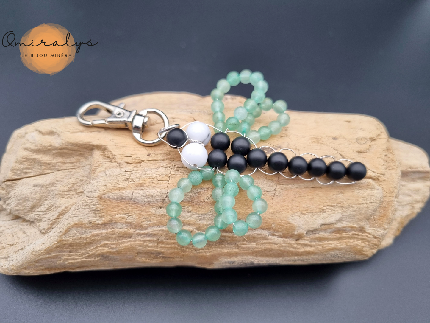 Porte-clés libellule, onyx mat, aventurine et howlite en perles posé sur un morceau de bois flotté. 