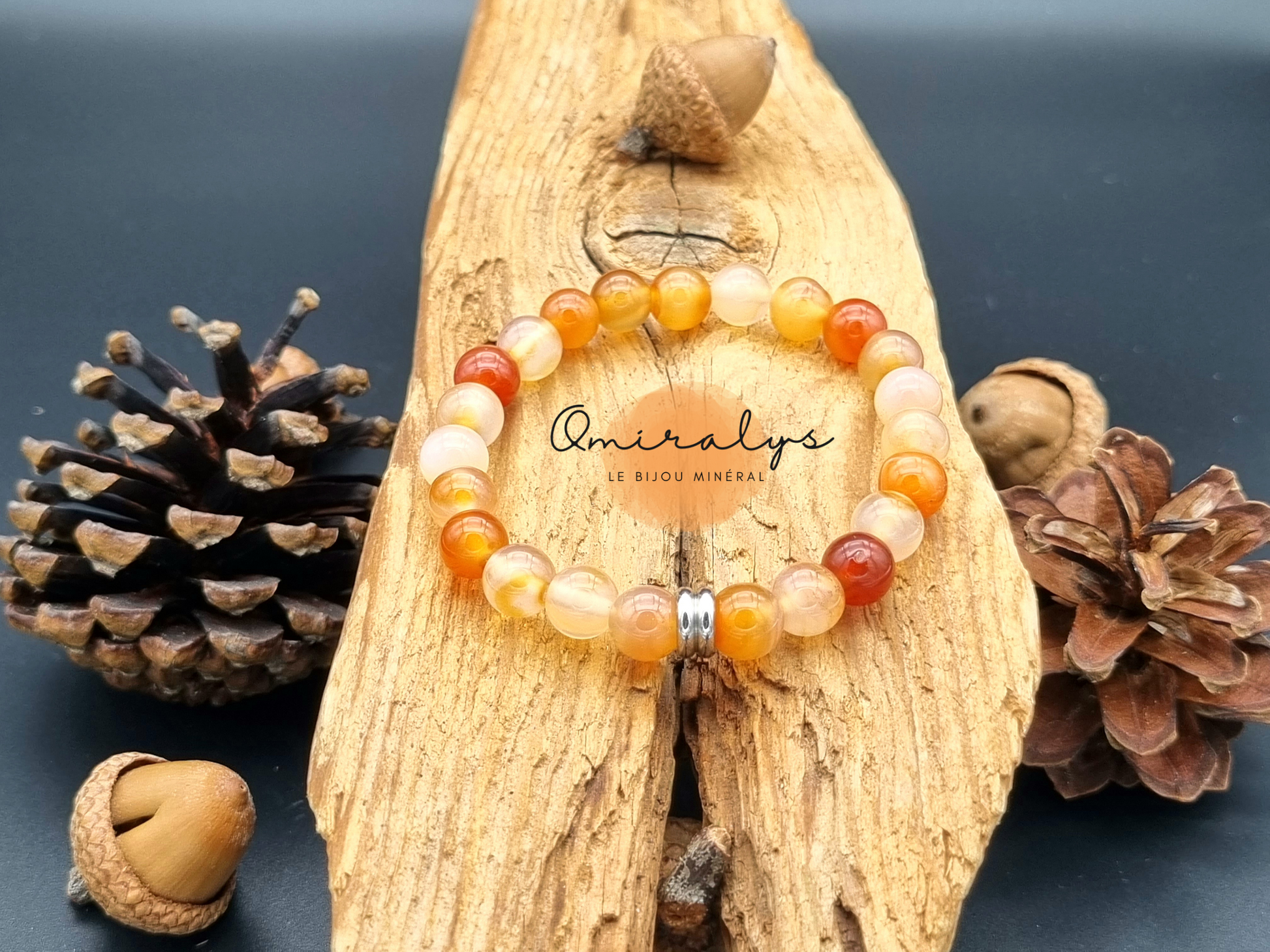 Bracelet cornaline multicolore qui repose sur un morceau de bois.